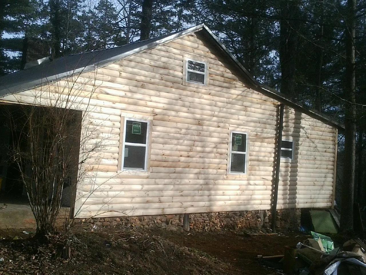 New log siding and dark metal roofing on a gable end in White Plains